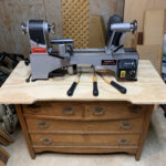 Benchtop wood lathe with chisels on dresser