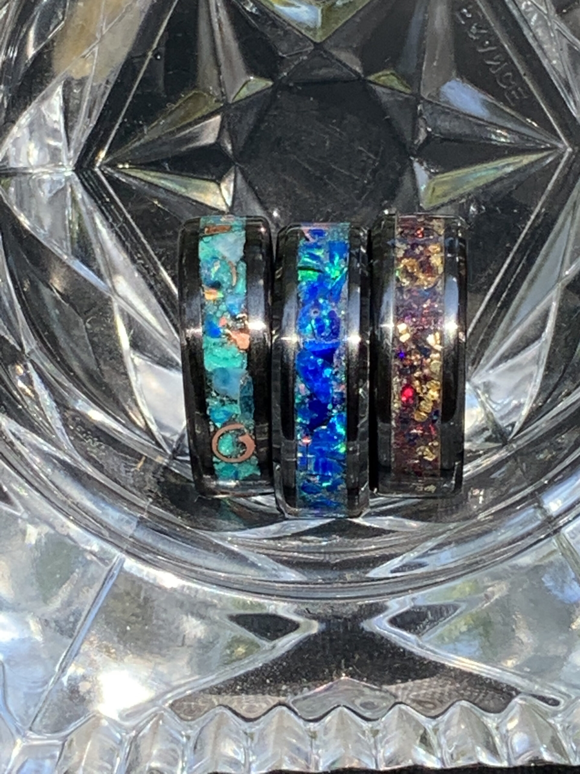 Three opal inlay rings in crystal dish