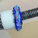 Blue glittery resin ring on threaded screw