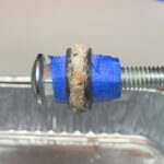 Threaded rod with blue tape and corroded washer