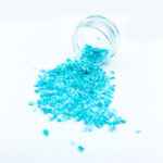Blue decorative glass chips spilling from jar