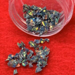 Iridescent opal chips spilling from clear container