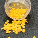 Small yellow flakes spilled from clear jar