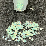 Spilled iridescent pastel chips from small container