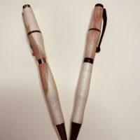 Two handcrafted wooden pens with metal accents